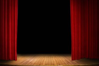 close up red stage curtain opening over wooden floor stage